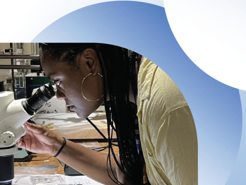 Student at microscope.