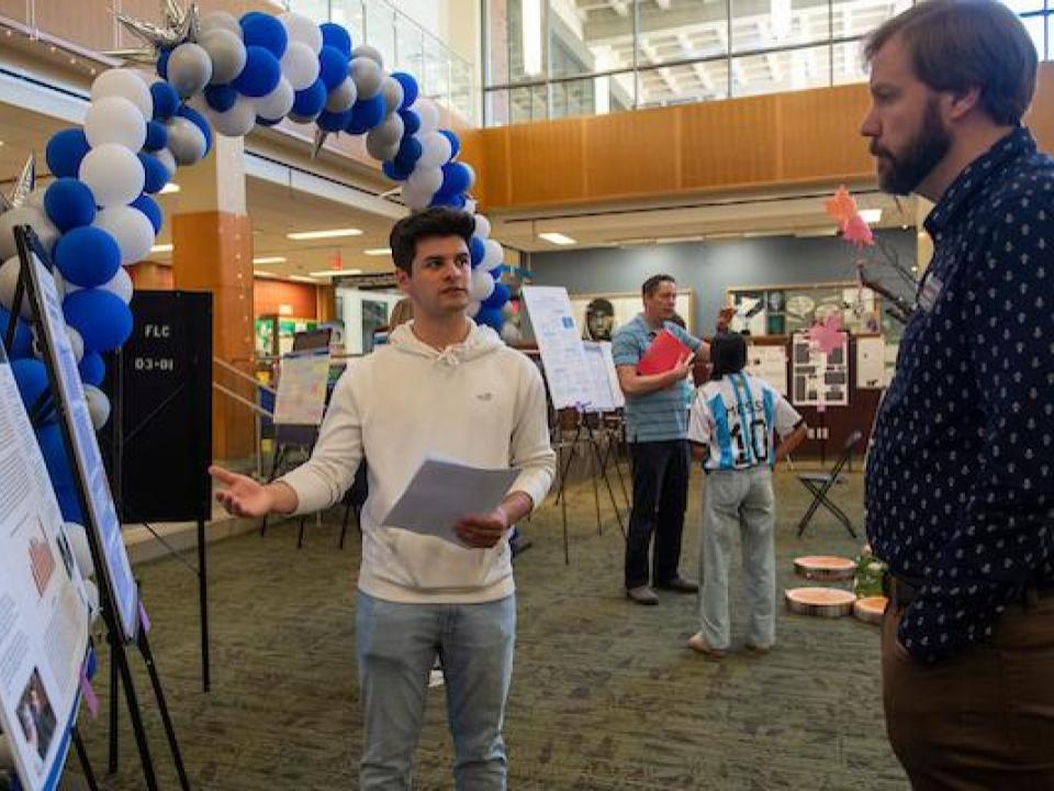 Student presenting a research poster.