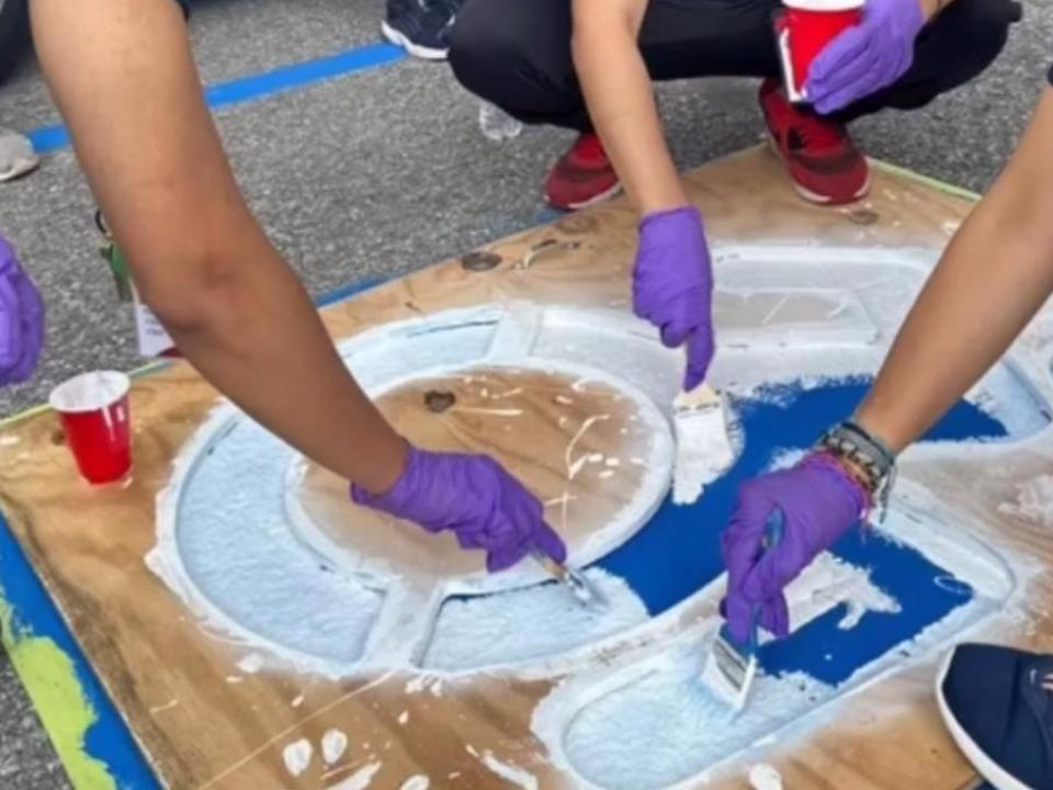 Hands painting outdoors.
