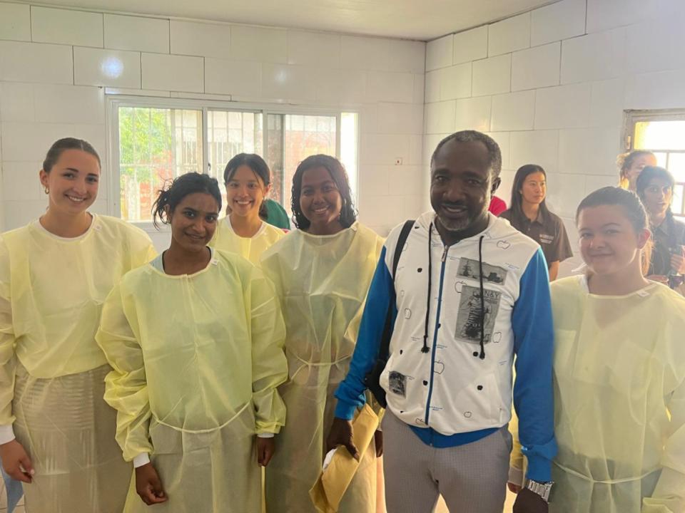 Students with professor in full medical dress doing research