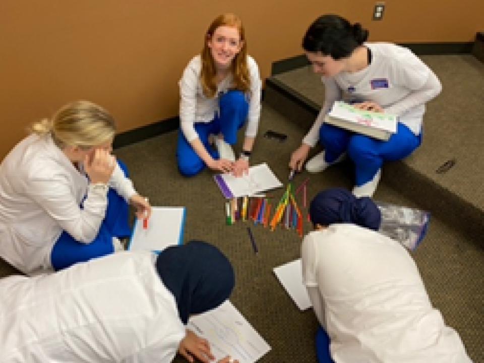 Nursing students sitting in a circle and collaborating to color code